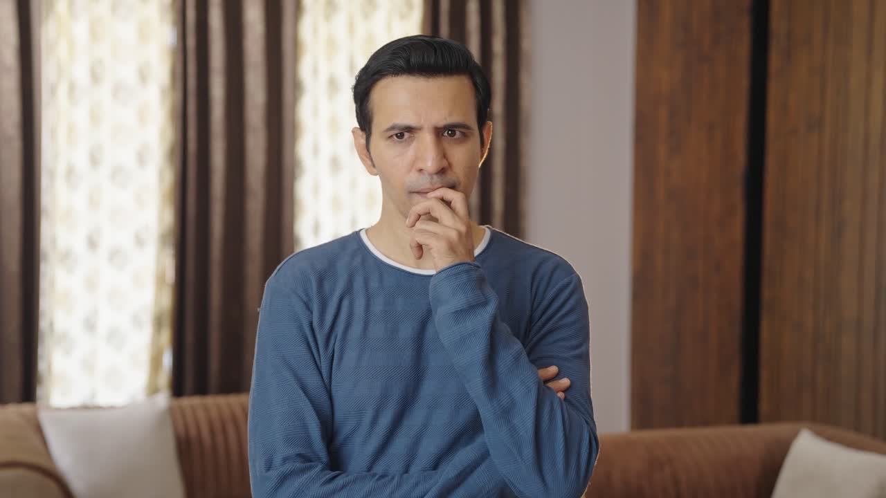 Middle aged Indian man thinking and observing