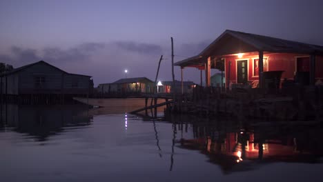 stilt houses reflection over water at night