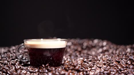 coffee cup with steam next to coffee beans on dark background in slow motion hd