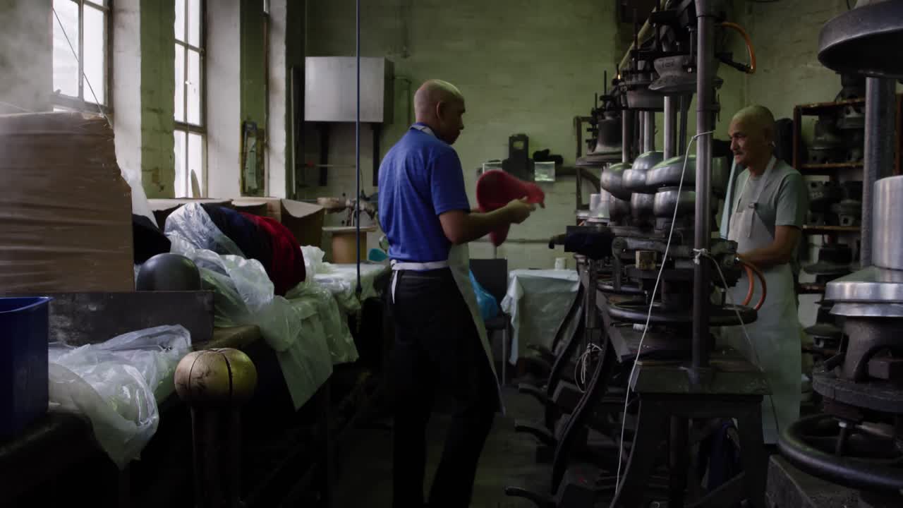 Mixed race men working at a hat factory