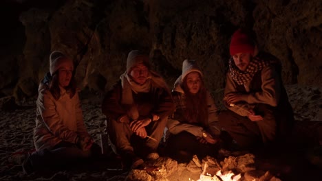 friends enjoying a campfire on a winter beach night