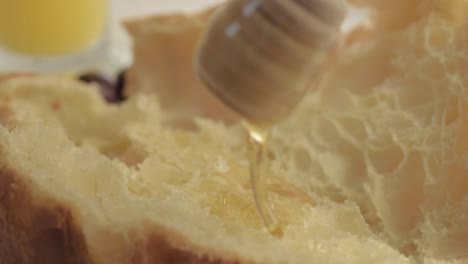 Drizzling-honey-on-fresh-baked-croissant-macro-shot