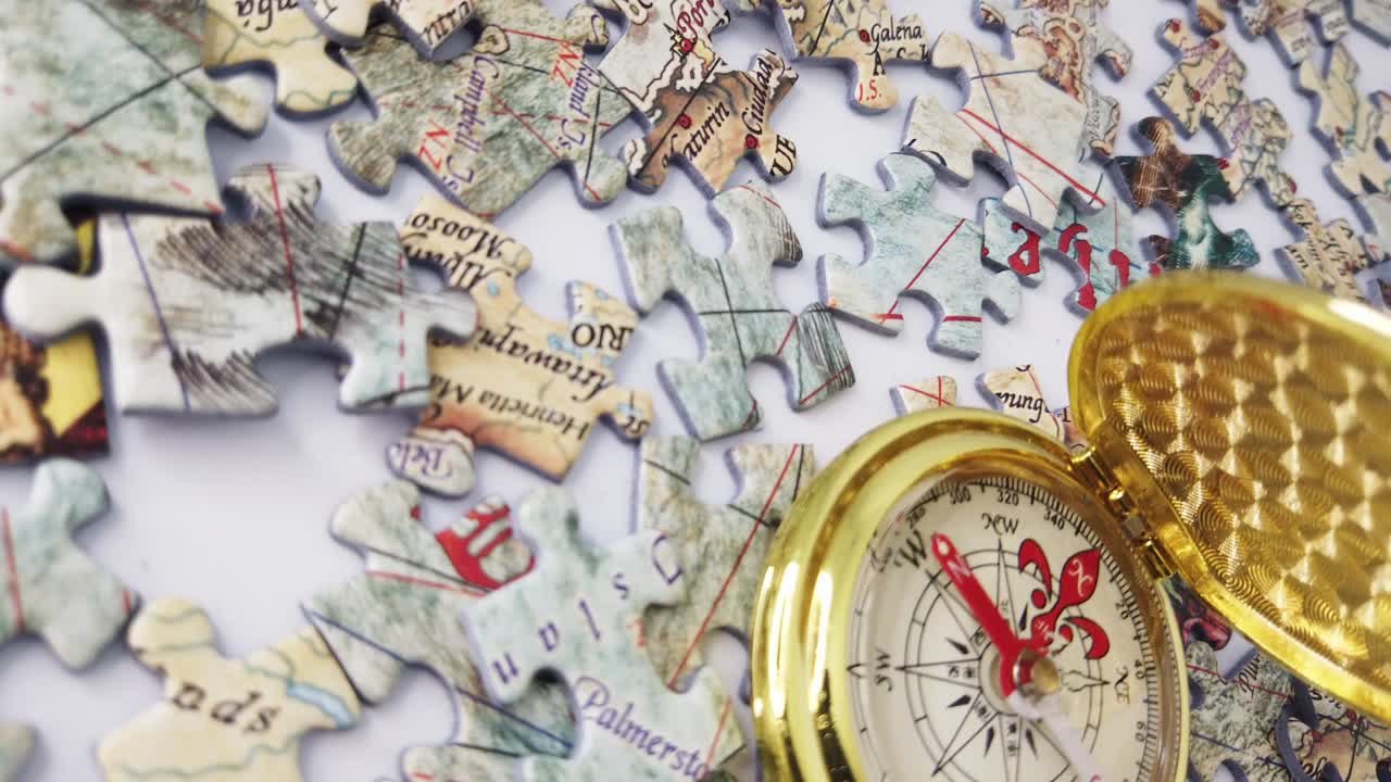 세계 지도의 흐릿한 직소 퍼즐 패닝, 길을 찾는 황금 나침반과 불확실성의 바다를 나타내는 더 많은 직소 퍼즐