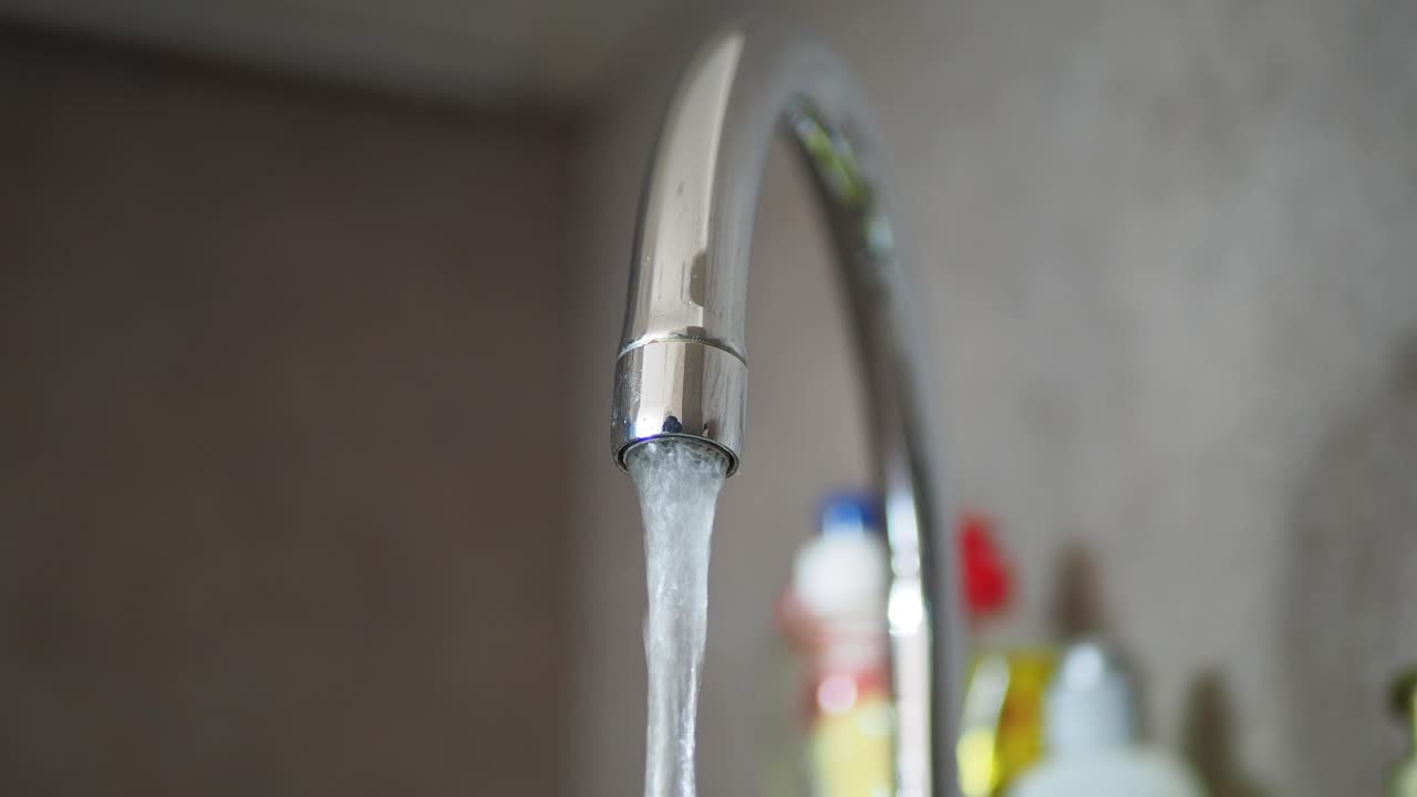 agua que fluye de un grifo de la cocina