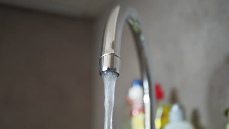 agua que fluye de un grifo de la cocina