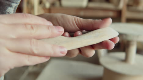 female potter choosing tools for work