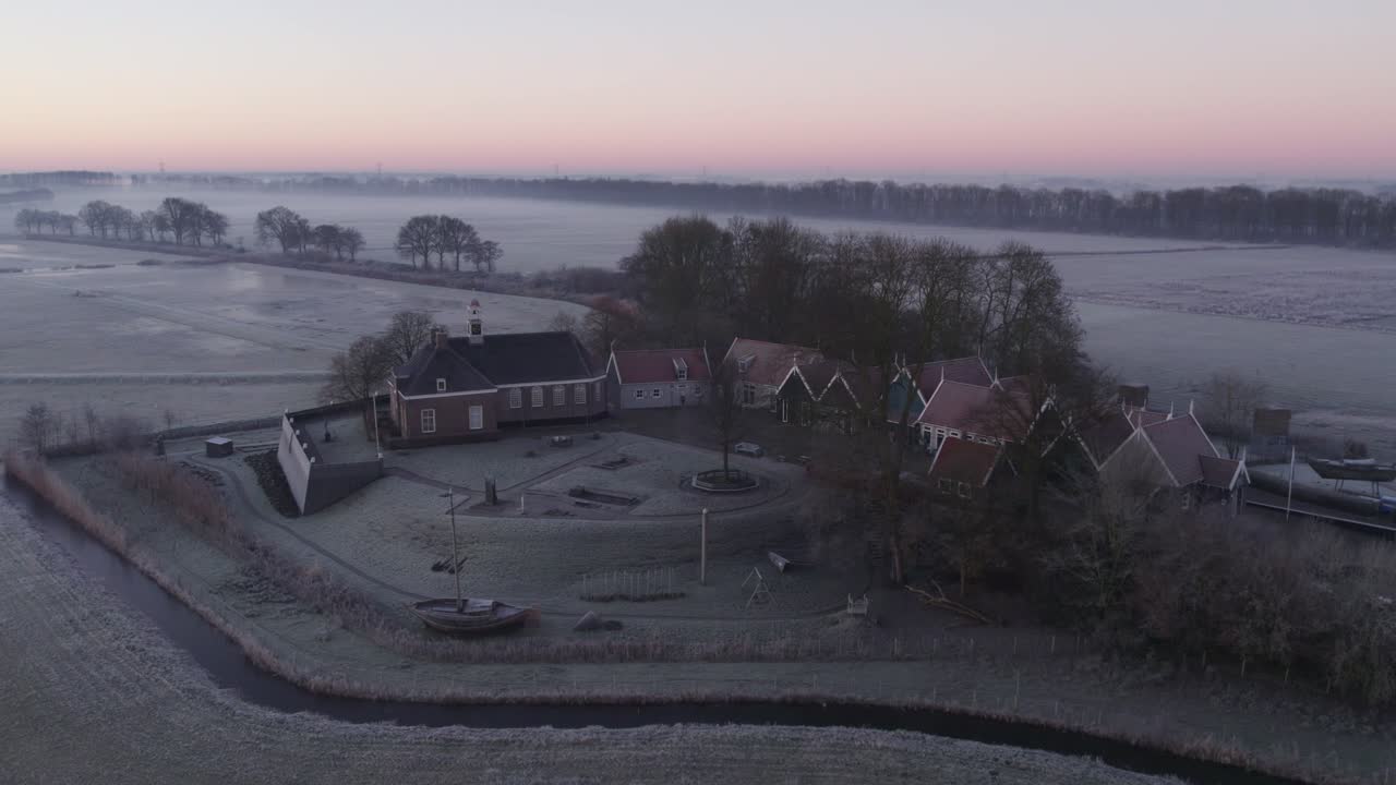 Kirke, hus og trær i landsby ved soloppgang, luftfoto, Schokland, Nederland
