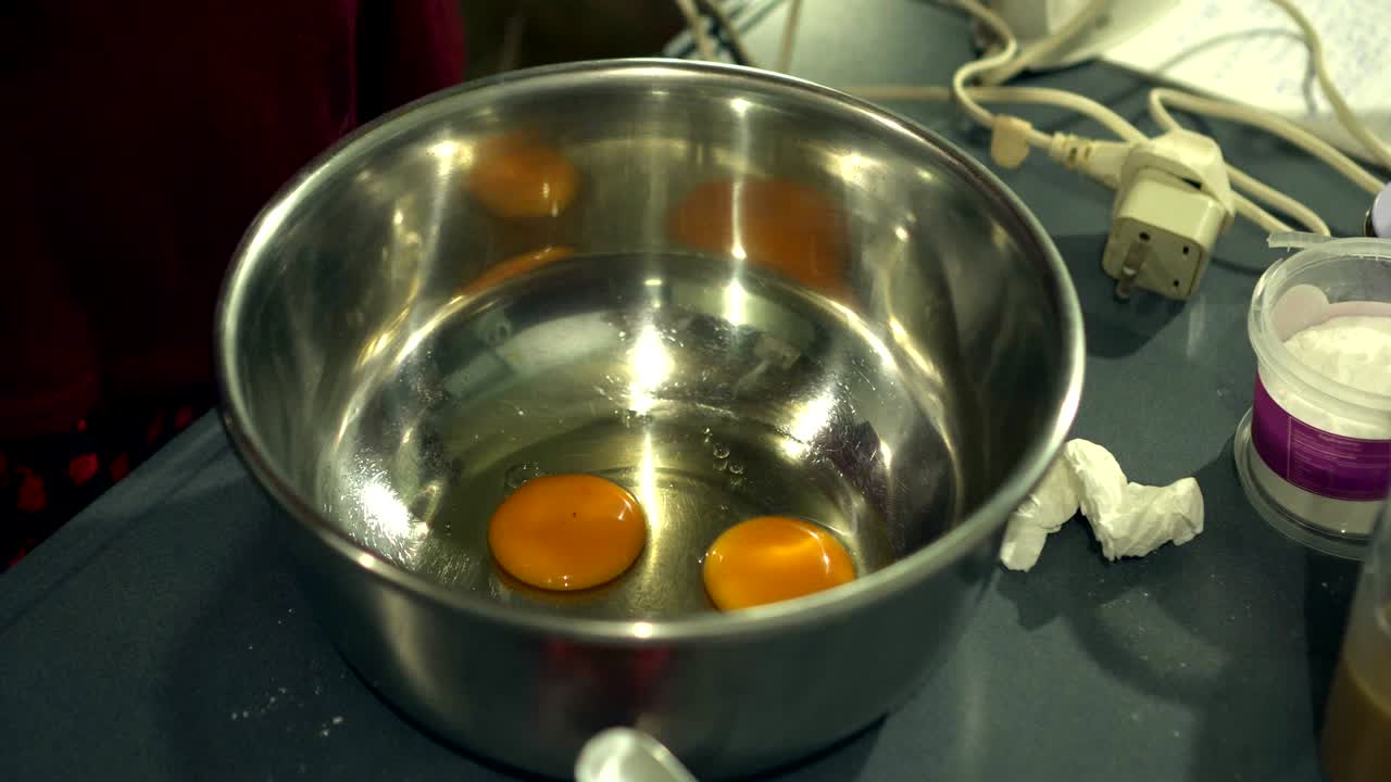 mujeres rompiendo huevos a mano en el cuenco