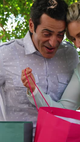 pareja sorprendida mirando en la bolsa de compras en un día soleado
