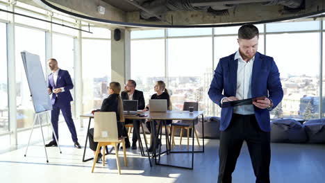 work of business people in modern office. young entrepreneur with a folder scattering blueprints on the background of group of businesspeople talk.