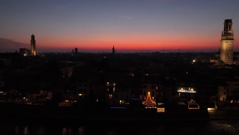 Seitliche-Schwenk-Drohnenaufnahme-Aus-Der-Luft-Der-Skyline-Der-Glockentürme-Von-Verona-Bei-Sonnenuntergang