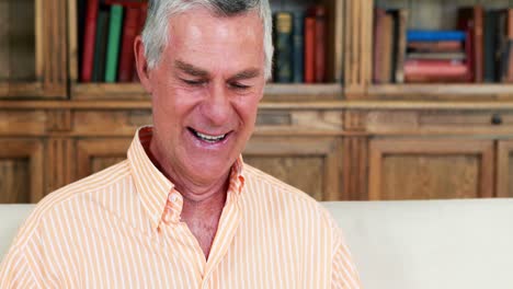 Senior-man-reading-newspaper-in-living-room