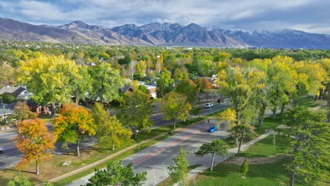 volando sobre liberty park y 700 east street con una hermosa vista de las montañas en salt lake city, utah.