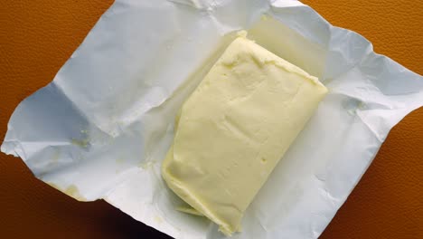 slice of a butter on a paper on table