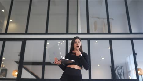 mujer mirando la computadora portátil con expresión de sorpresa