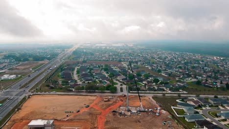 Toma-De-Dron-De-4k-De-Una-Gran-Grúa-De-Construcción-Levantando-A-2-Trabajadores-De-La-Construcción-Que-Están-Reparando-Y-Cableando-Una-Nueva-Torre-De-Telefonía-Celular-En-El-Estado-De-Florida