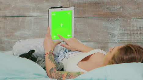 vista trasera de una mujer en pijama sosteniendo una computadora tablet