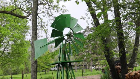 wind turning a small green lawn windmill in countryside