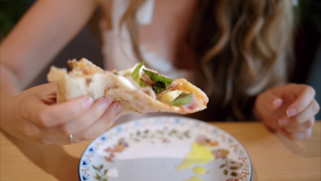 Woman eating a slice of pizza at an italian restaurant