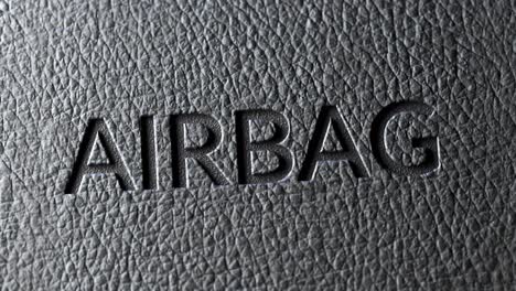 Primer-Plano-De-Un-Cartel-De-Airbag-De-Seguridad-En-La-Tapicería-De-Cuero-Oscuro-Del-Coche.-Textura-Del-Tablero-Iluminada-Por-Una-Luz-Suave-Que-Muestra-Intrincados-Detalles-De-Textura.-La-Mejor-Protección-Para-Los-Pasajeros-De-Un-Automóvil-Durante-Un-Accidente.