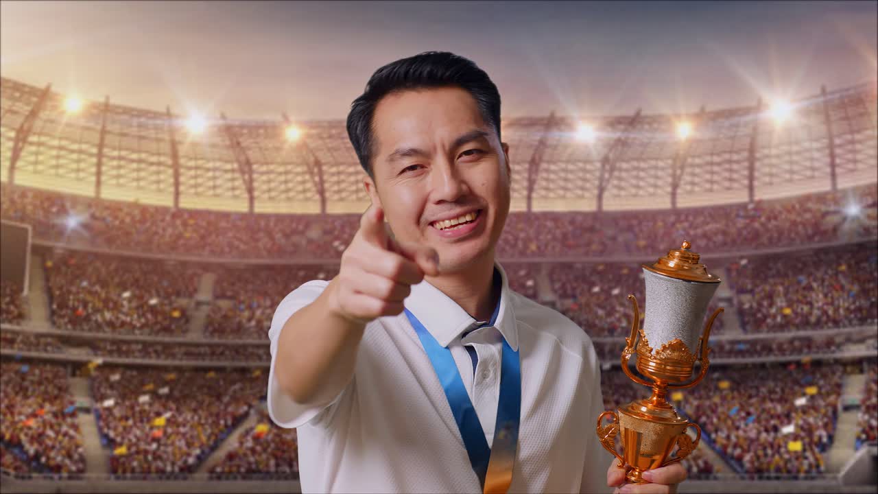 경기장에서 트로피를 들고 승리를 축하하는 남자