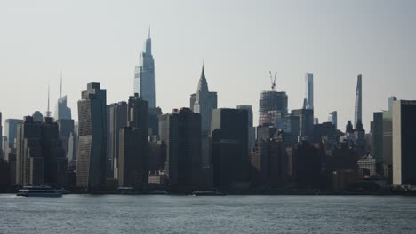 majestic new york skyscrapers such as the chrysler tower and one vanderbilt look on as a luxury riverboat yacht slices through the river's glimmer