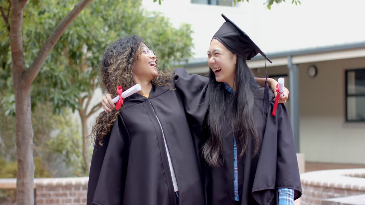 Gioia del giorno della laurea per un'adolescente e un'adolescente asiatica, con spazio per il testo