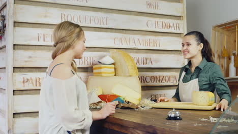 el amable vendedor de queso informa al comprador que debe estar detrás del mostrador sobre el queso más grande