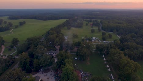 Fly-over-4k-Drone-slow-pull-back-of-rural-music-and-art-festival-on-historic-farm