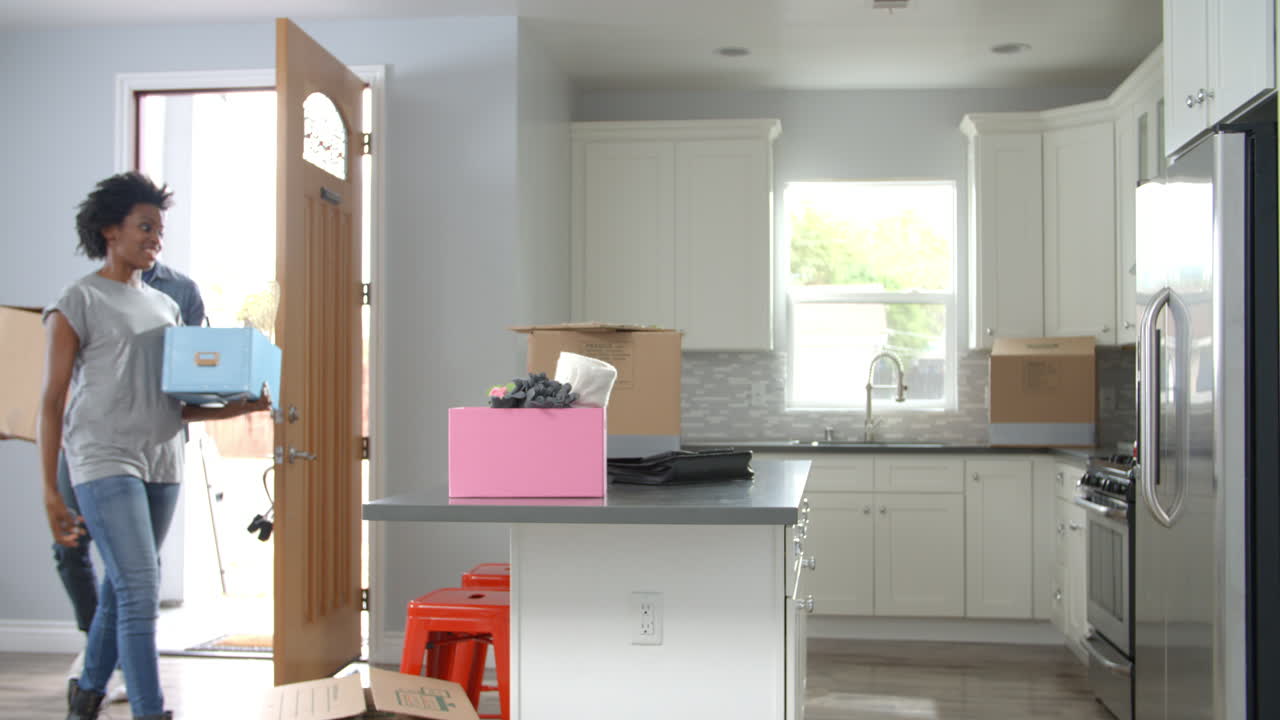 젊은 아프리카계 미국인 부부가 새로운 집으로 이사하고 있습니다.