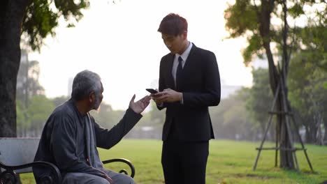 a thoughtful encounter: a businessman speaks with a homeless man in the park, reflecting on society's interactions and disparities in urban environments