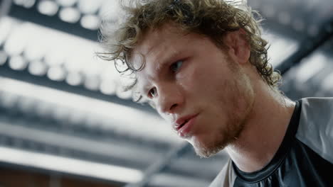 sportsman taking break in sport club. water drops falling from sad fighter face