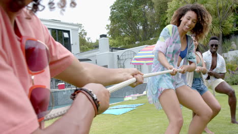 diverse friends enjoy a tug-of-war game outdoors