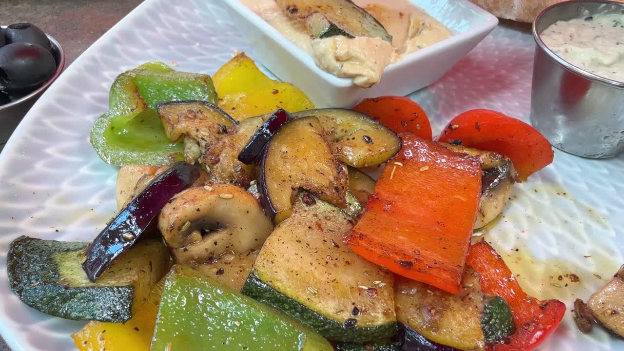 Close up of eating healthy antipasti vegetables with olive oil and hummus