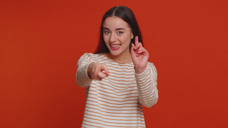 woman pointing to camera, looking with playful happy expression, making choice, showing direction