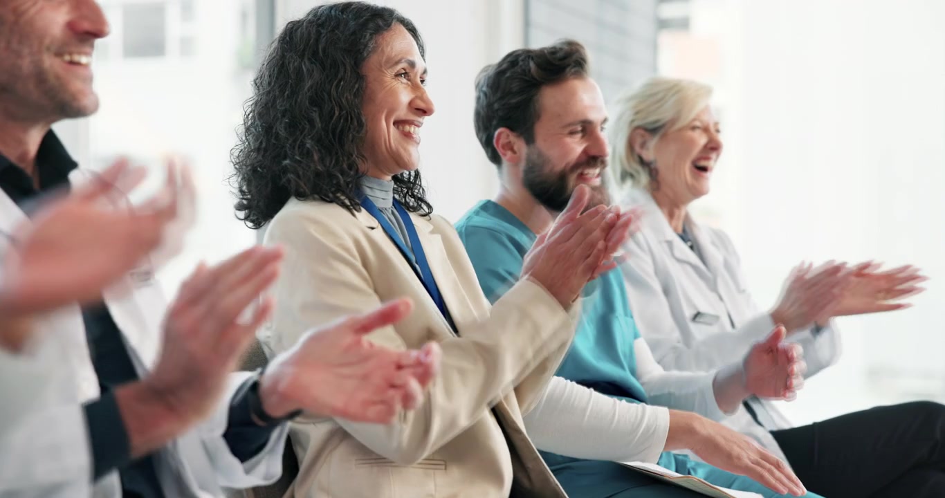 Diverse Group of Medical Professionals Applauding During a Meeting