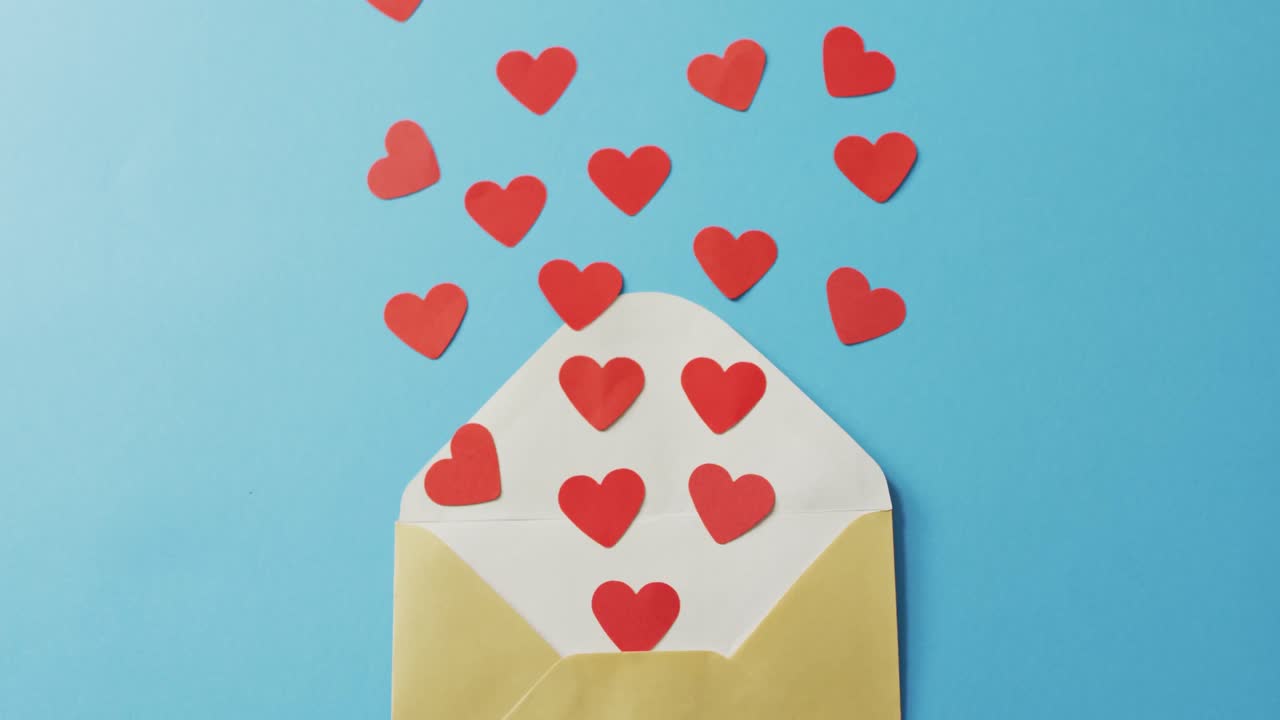 Envelope with paper hearts on blue background at valentine's day