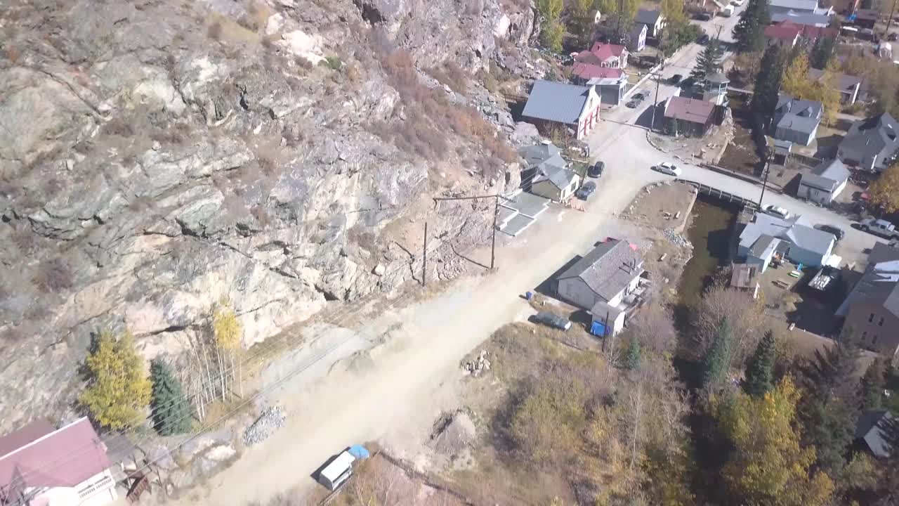 4k의 푸른 하늘과 함께 거의 유령 도시와 활기찬 아스펜 나무 풍경을 보여주는 은색 깃털 콜로라도의 돌리 틸트 샷