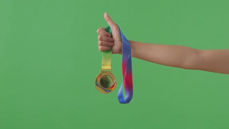 golden medal in hand. green screen background