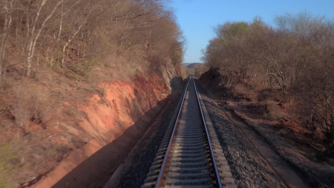 punto de vista de un tren en movimiento que atraviesa un paisaje árido