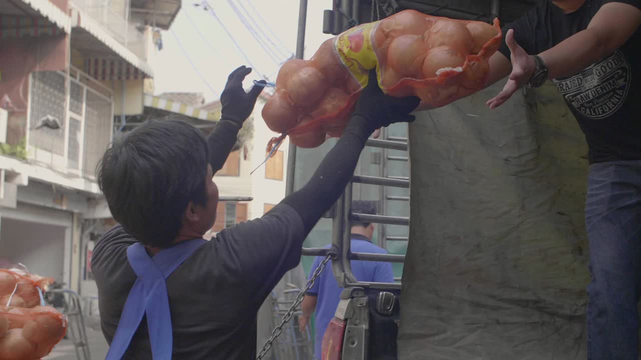 мужчины грузят лук на грузовик