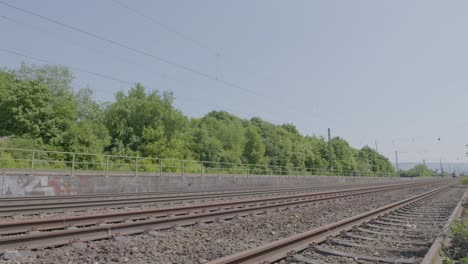 la velocidad del tren rojo en las vías a través de un paisaje verde exuberante en un día soleado