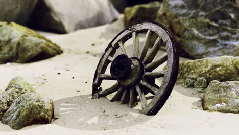 Old wooden wheel partially buried in sandy terrain surrounded by rocks