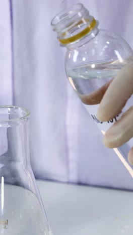 scientist pouring liquid into a beaker