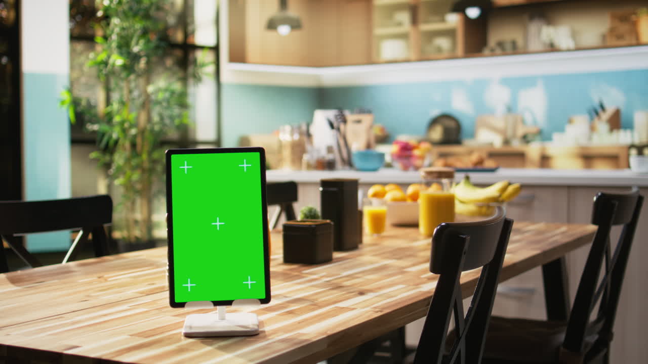 Vertical green screen on tablet in empty wooden stylish kitchen space