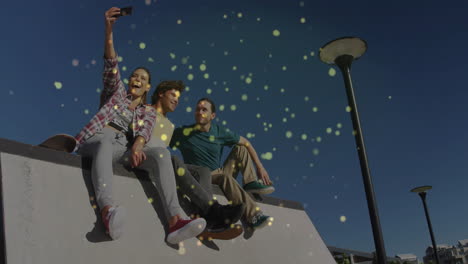 three friends sitting on ledge in plaza, taking selfie with glowing marketing icons overlay