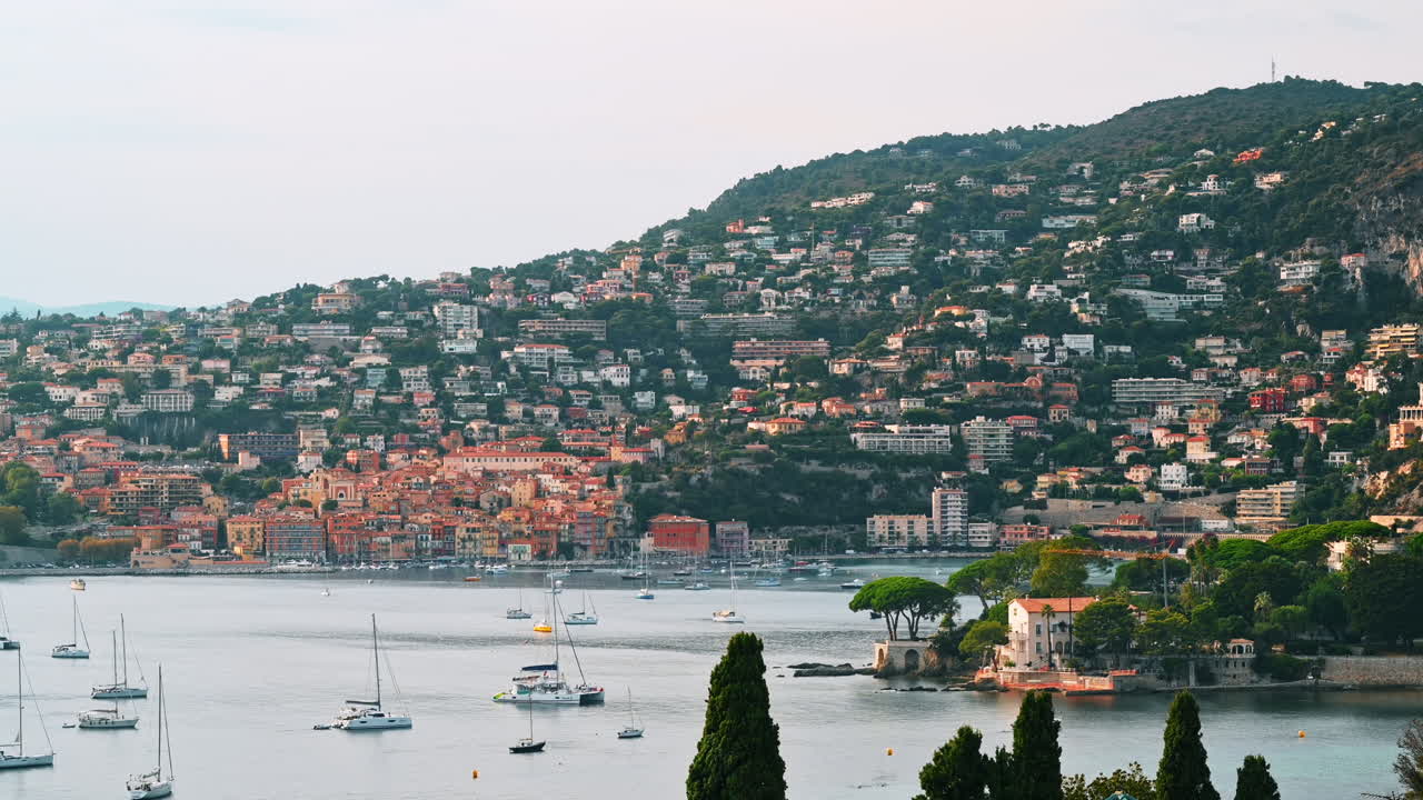Vista della costa del Mar Mediterraneo a Saint-Jean-Cap-Ferrat, colline con vegetazione, edifici residenziali, yacht, Francia