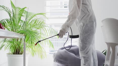 health worker wearing protective clothes cleaning the office using disinfectant