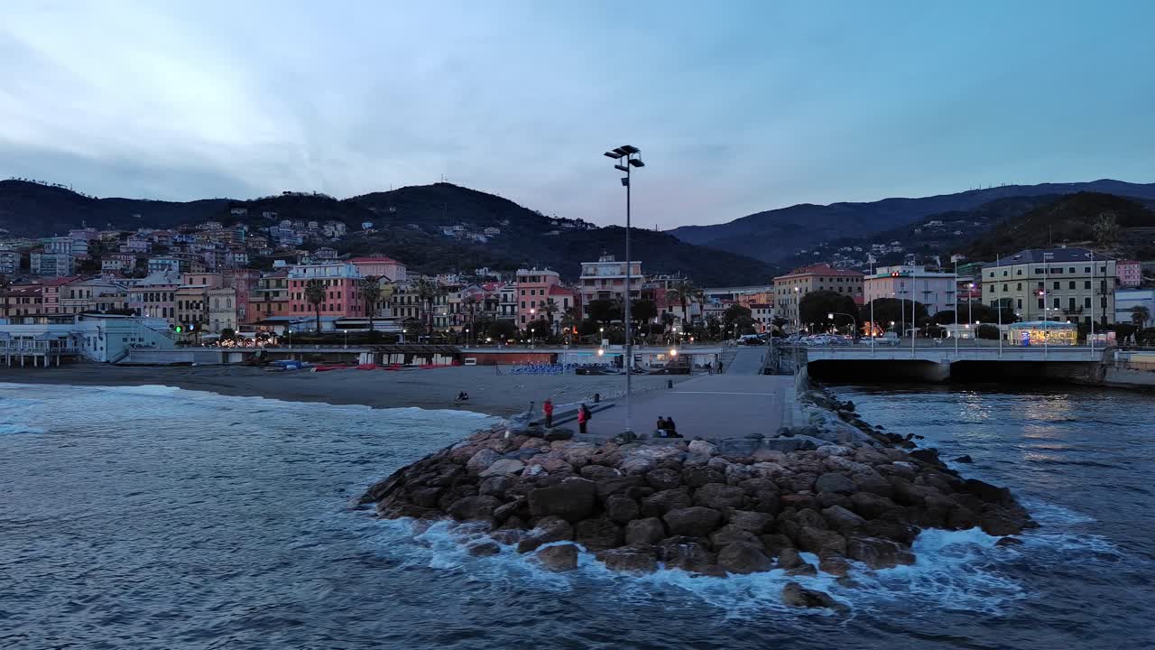Ripresa aerea da drone sulla costa e sul mare di Varazze, Liguria, Italia al tramonto o crepuscolo, ora blu