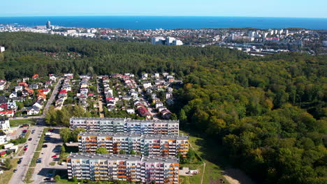 Toma-Aérea-Inclinada-Hacia-Arriba-Del-Distrito-De-Witomino-Y-La-Ciudad-De-Gdynia-En-El-Cielo-Azul-De-Fondo,-Polonia